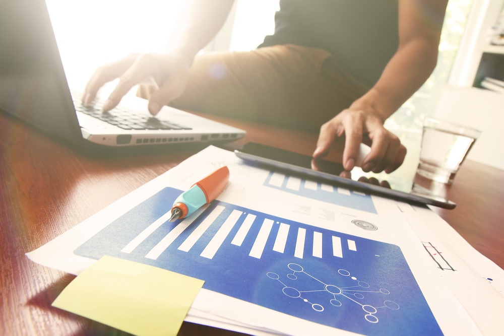 Young creative designer man working at office and social network media and graph chart diagram as concept with overcast exposure effect.jpeg